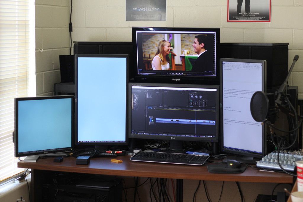 A desk with five computer monitors