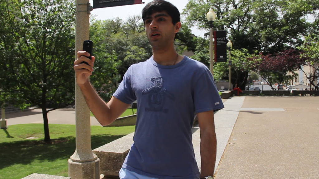 A person walking on a college campus with a 360 camera